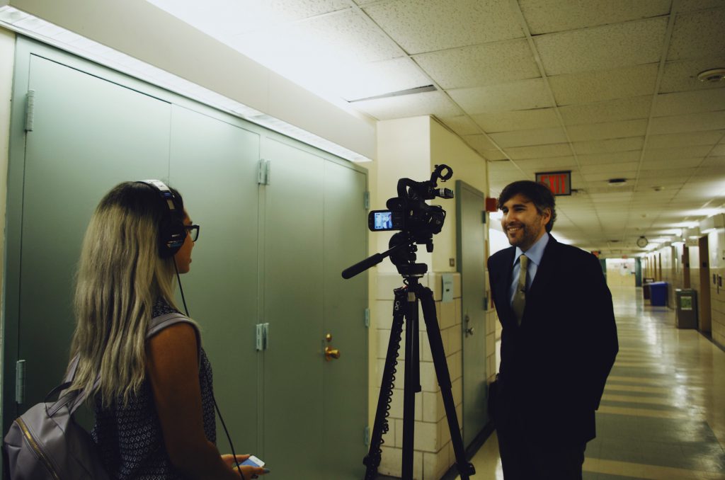 Journalism student Caitlin Munson interviewing Times correspondent Michael Grynbaum. Munson also interviewed other panel participants and will be producing a news story on the event for a video news reporting class.