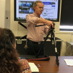 Chief CLT Renato Tonelli demonstrates video gear to students from the Studio News Production class.